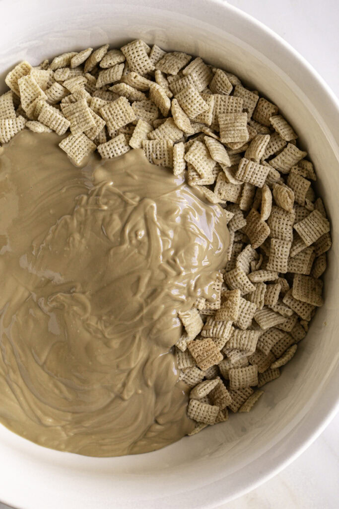 melted white chocolate and sunflower seed butter poured over the chex rice cereal in a large bowl.