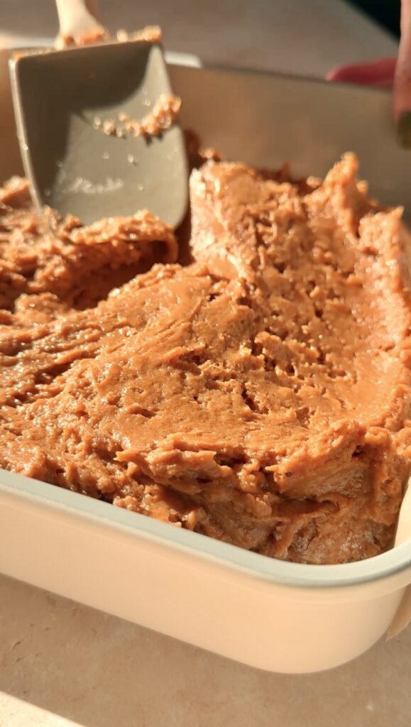 spreading the pumpkin olive oil cake batter into a baking pan.