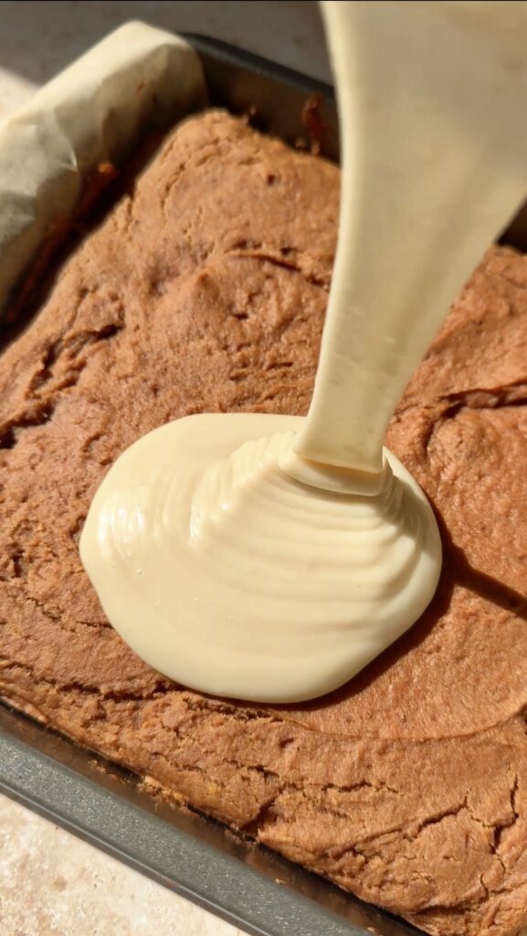 pouring the maple olive oil glaze over the pumpkin cake.