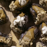 overhead shot of pumpkin pie stuffed dates on a wooden cutting board.