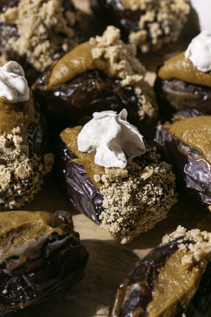 3/4 shot of pumpkin pie stuffed dates on a wooden cutting board.