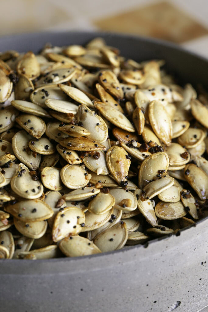 a close up shot of everything bagel roasted pumpkin seeds in a bowl.