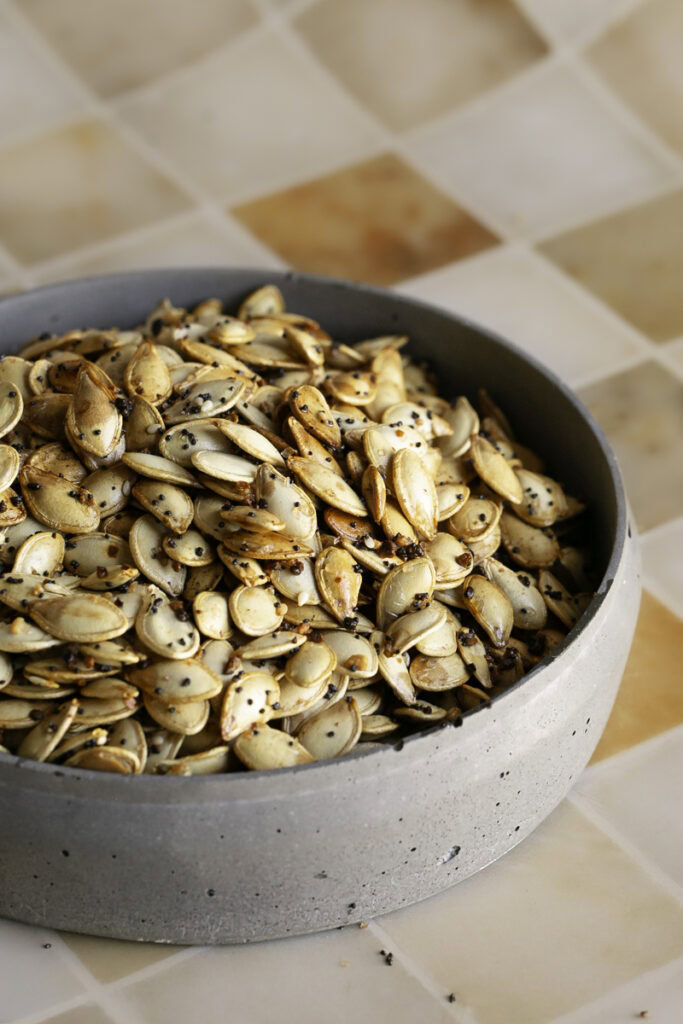 a bowl full of everything bagel roasted pumpkin seeds.