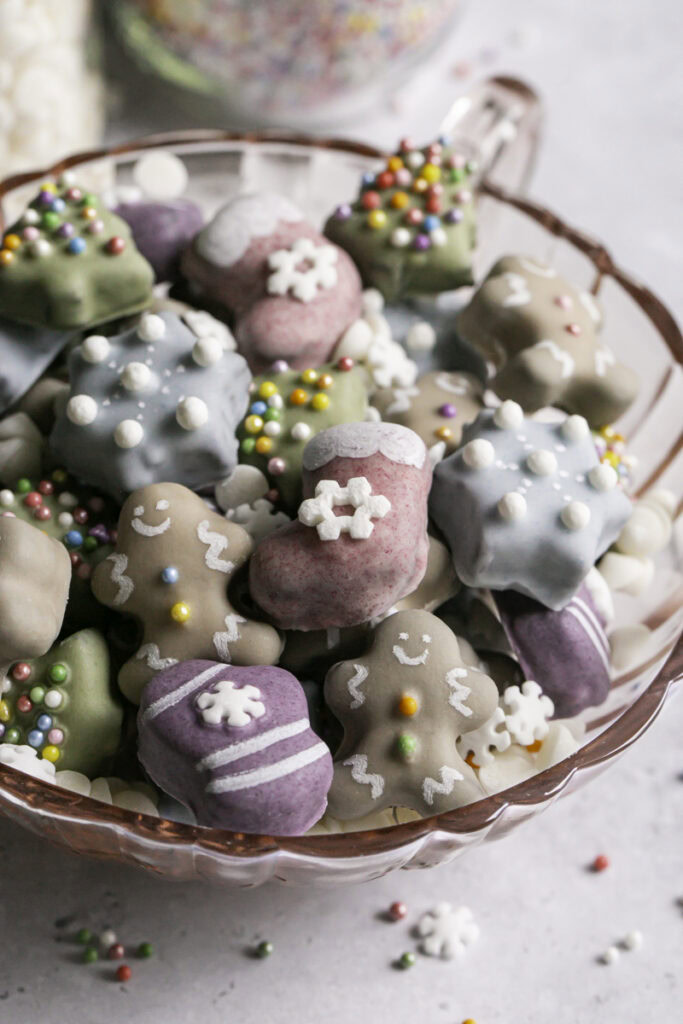 close up 3/4 image of all of the mini Christmas cookies in a pink glass mug.