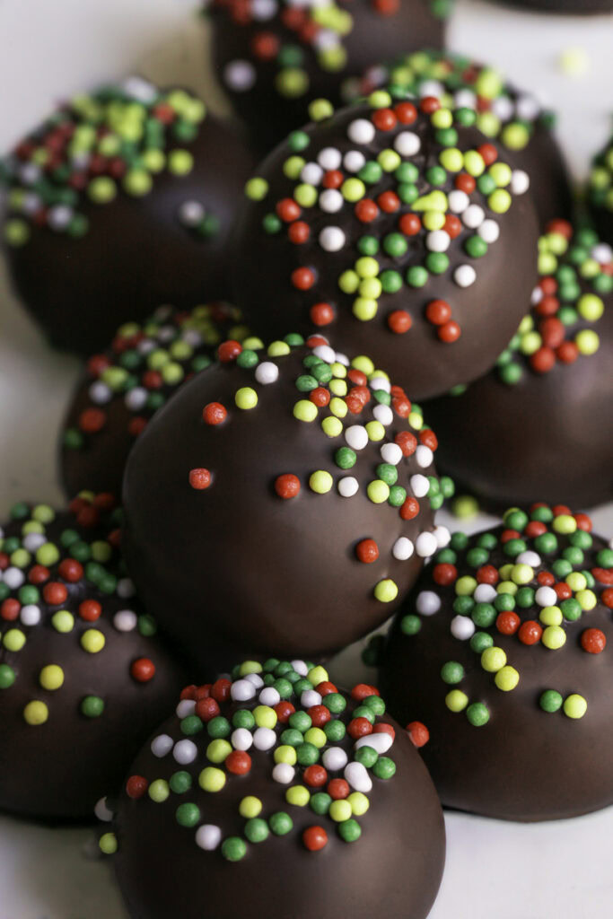 close up of Easy No-Bake Chocolate Gingerbread Almond Flour Cookie Dough Bites stacked on top of one another.