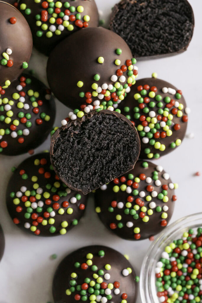 overhead shot of No-Bake Chocolate Gingerbread Almond Flour Cookie Dough Bites, the one on top sliced in half to reveal the cookie dough filling.