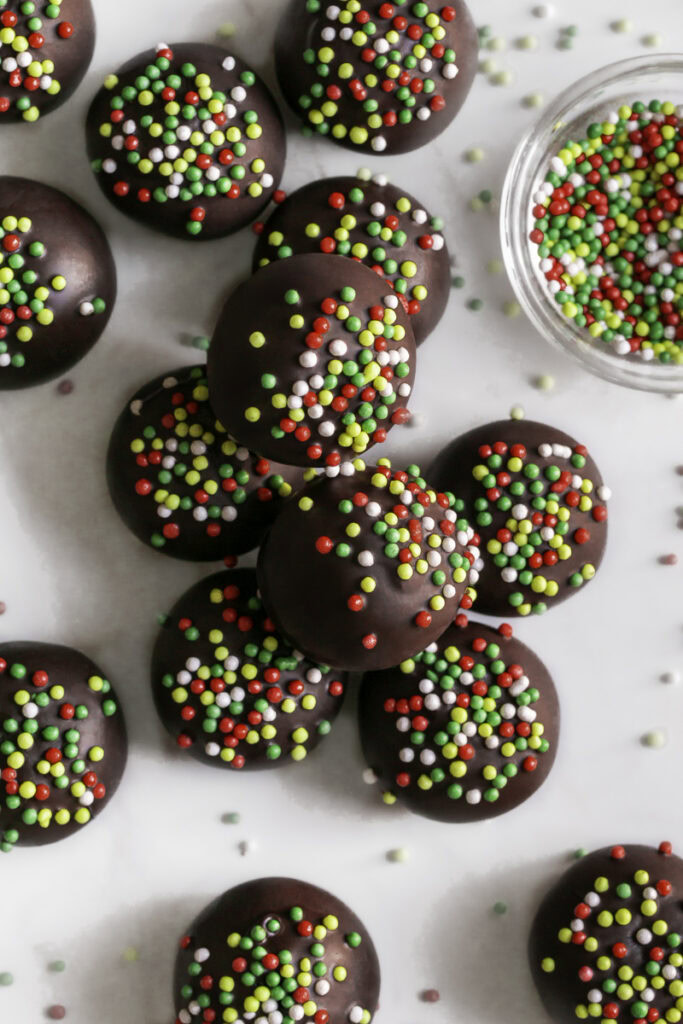 overhead shot of No-Bake Chocolate Gingerbread Almond Flour Cookie Dough Bites and a bowl of sprinkles.