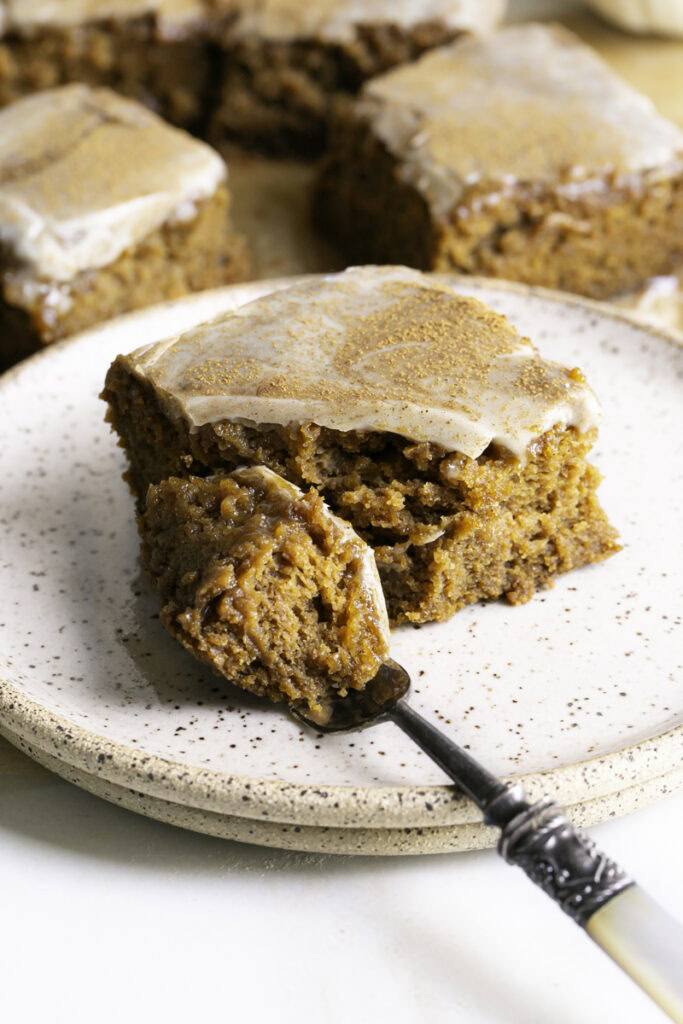 a slice of pumpkin olive oil cake with a fork cutting off a piece of the cake.