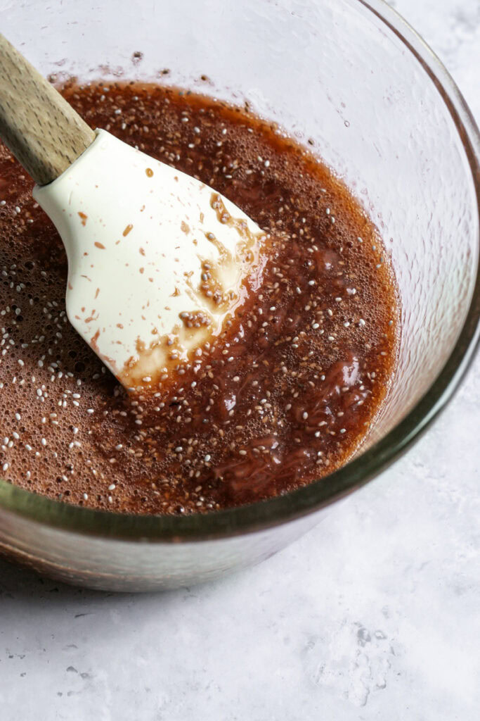 stirring the chia seeds into the jam with a spatula.