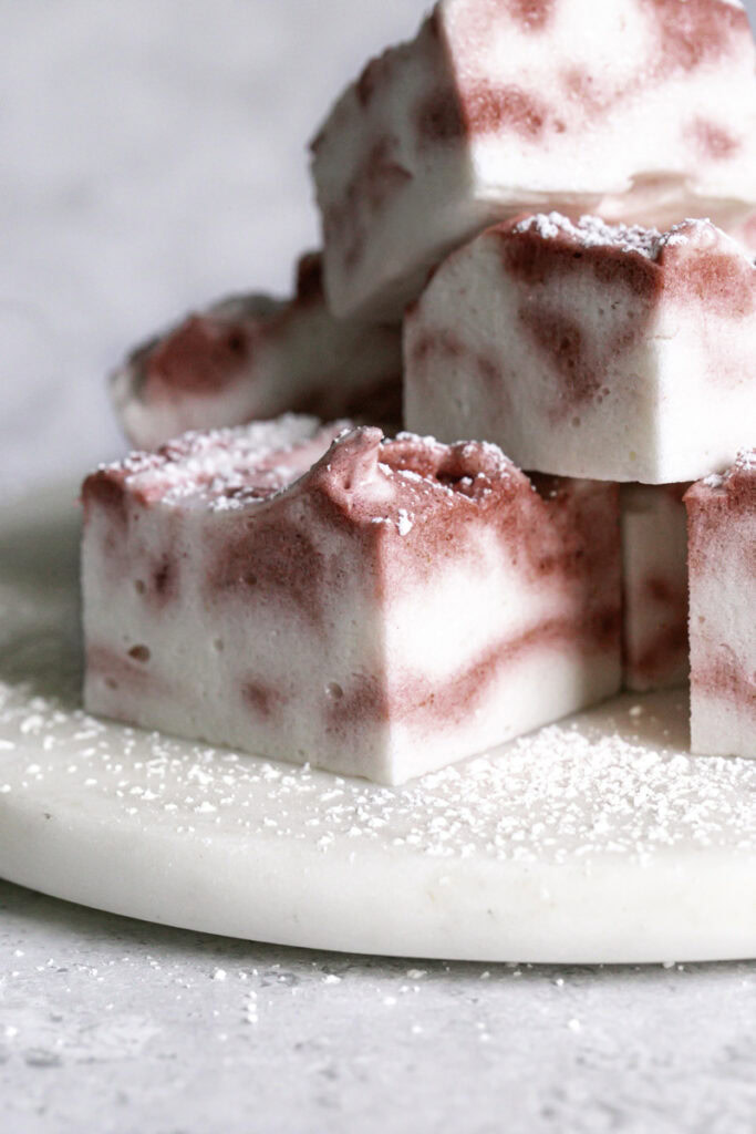 Vegan Peppermint Swirl Marshmallows cut into squares stacked on top of one another.