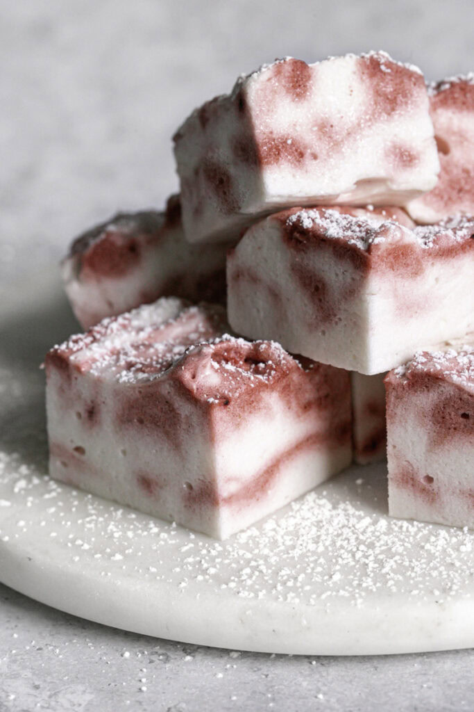 Vegan Peppermint Swirl Marshmallows cut into squares stacked on top of one another.