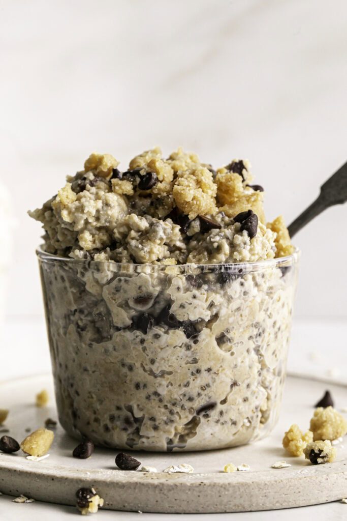 close up shot of glasses of chocolate chip cookie dough overnight oats, one with a spoon in it.