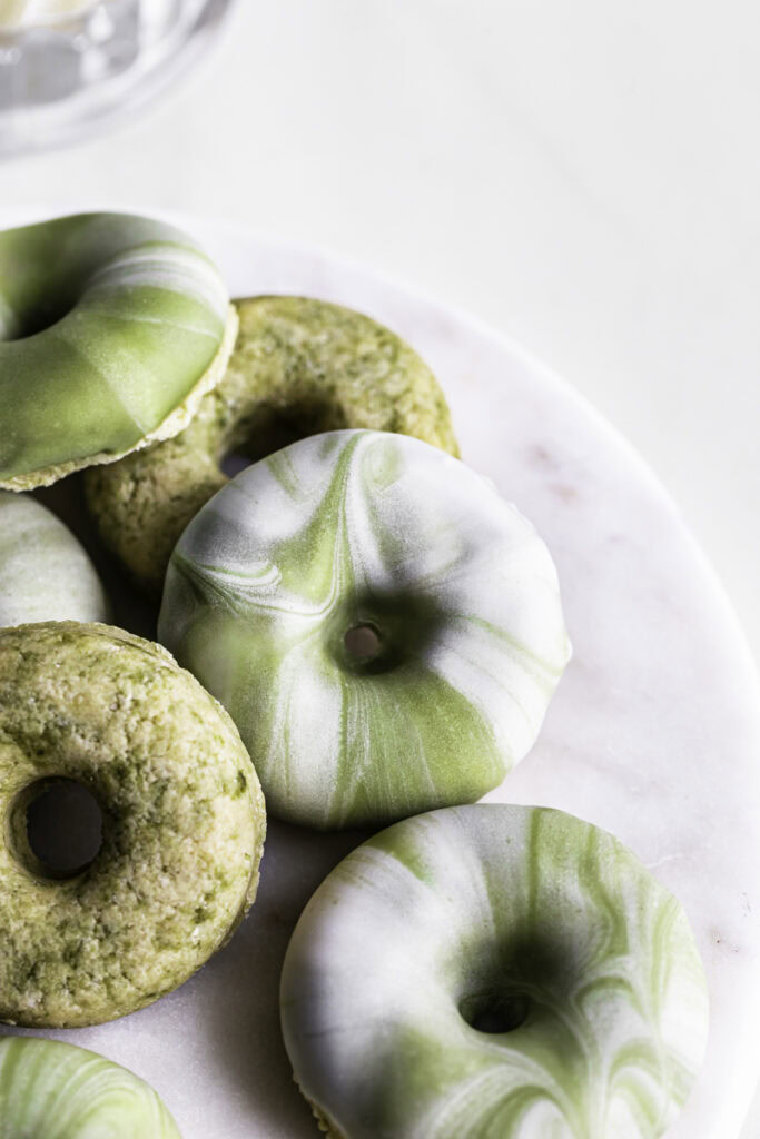 overhead shot of No-Bake Protein Matcha Donuts on a round marble plate.