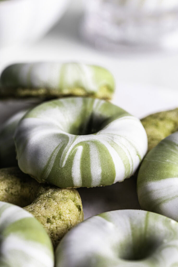 close up of No-Bake Protein Matcha Donuts piled on top of one another.