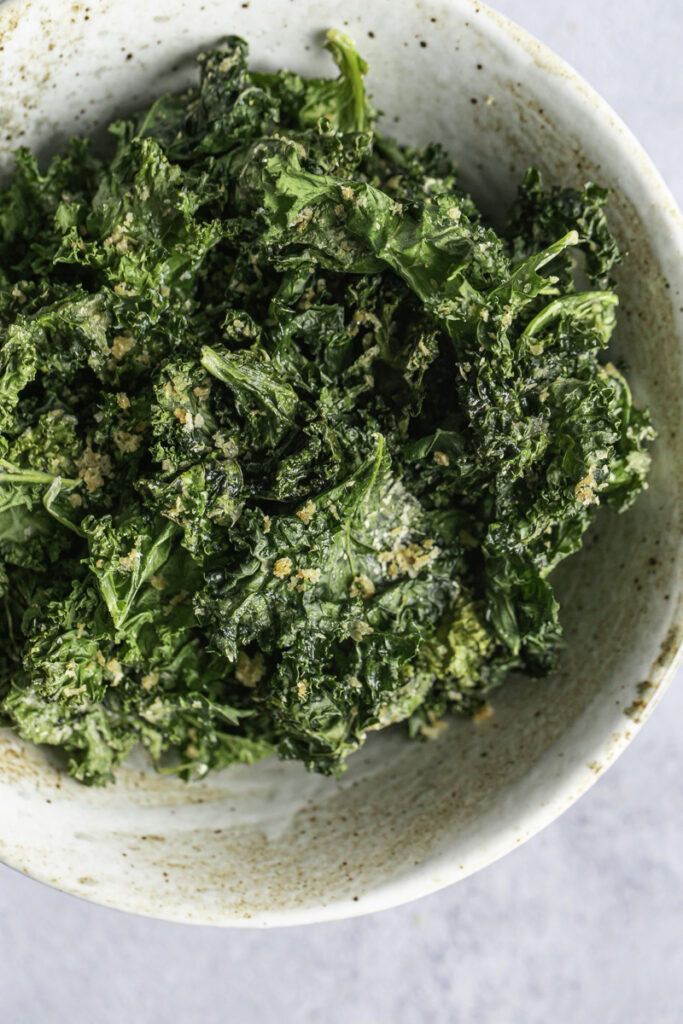 close up overhead shot of Cheesy Nutritional yeast Kale Chips in a bowl.