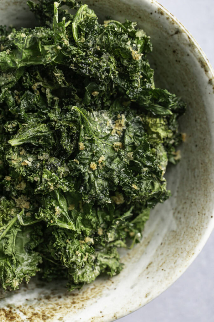 close up overhead shot of Cheesy Nutritional yeast Kale Chips in a bowl.
