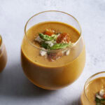 close up of a glasses filled with cherry tomato gazpacho.