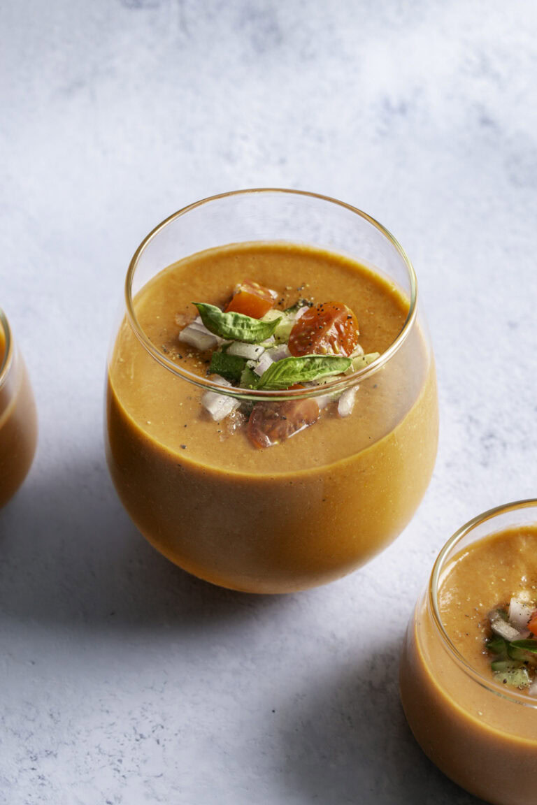 close up of a glasses filled with cherry tomato gazpacho.
