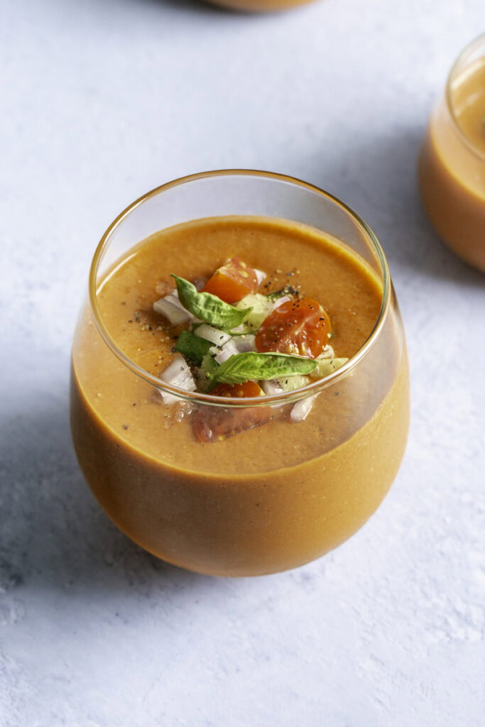 close up of a glass filled with cherry tomato gazpacho.