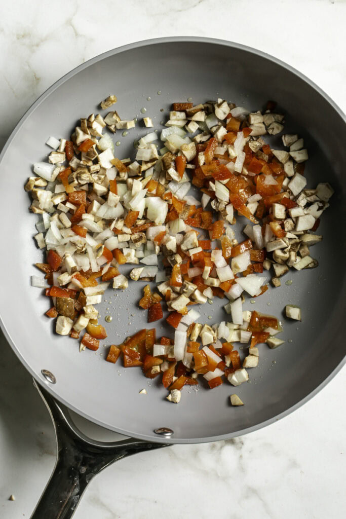 diced onion, mushroom, red bell pepper in a skillet.