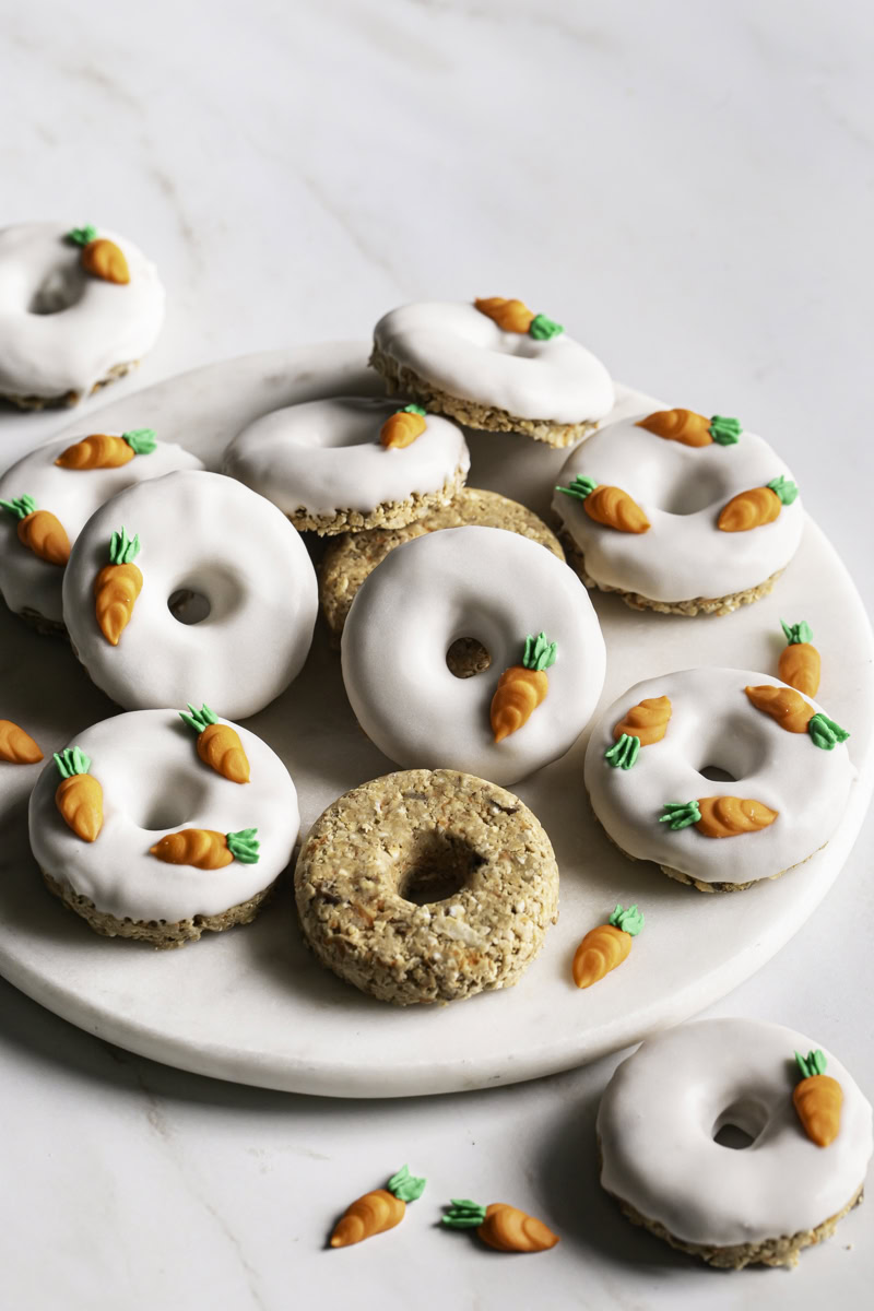 No-Bake Carrot Cake Protein Mini Donuts piled on a round marble plate.