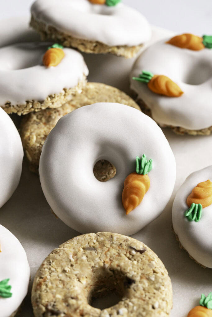 close up overhead of No-Bake Carrot Cake Protein Mini Donuts piled on a round marble plate.