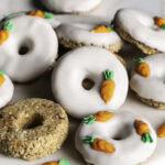 Close up of No-Bake Carrot Cake Protein Mini Donuts piled on a round marble plate.