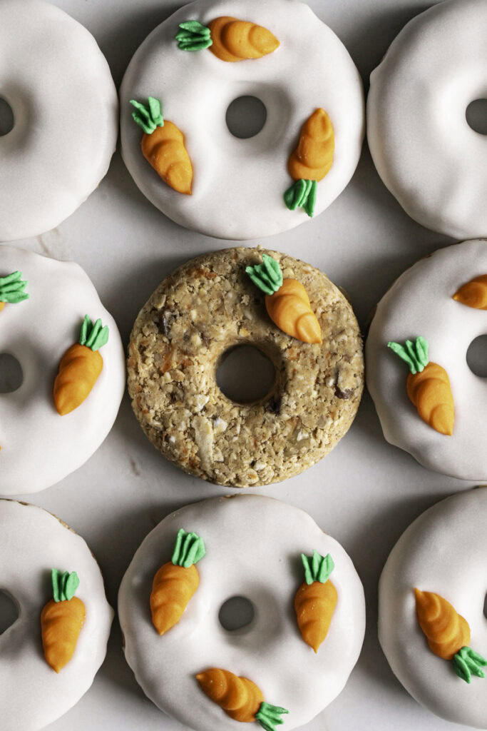 close up of 9 no-bake carrot cake protein mini donuts lined up next to each other in a square shape.