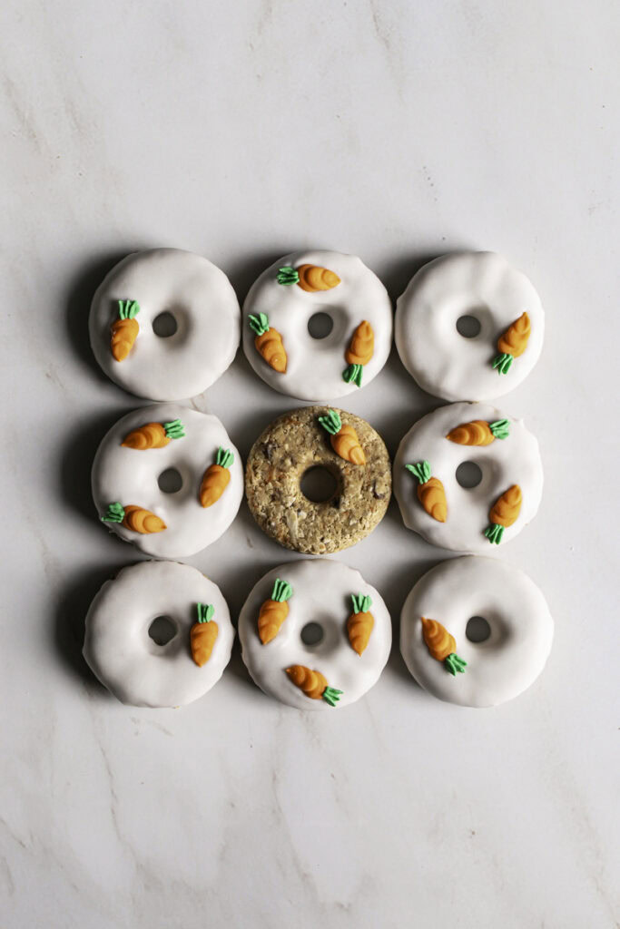9 no-bake carrot cake protein mini donuts lined up next to each other to make a square shape.
