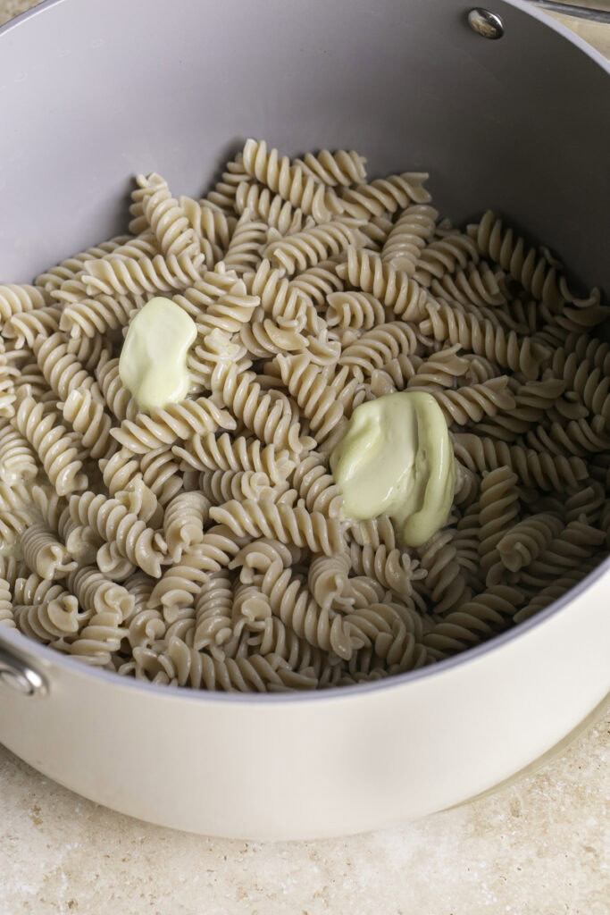 cooked rotini pasta in a pot with butter.