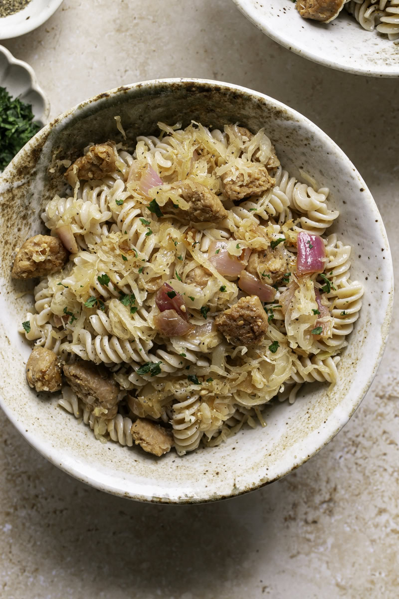 a close up of a bowl of vegan Bratwurst & Sauerkraut Pasta.