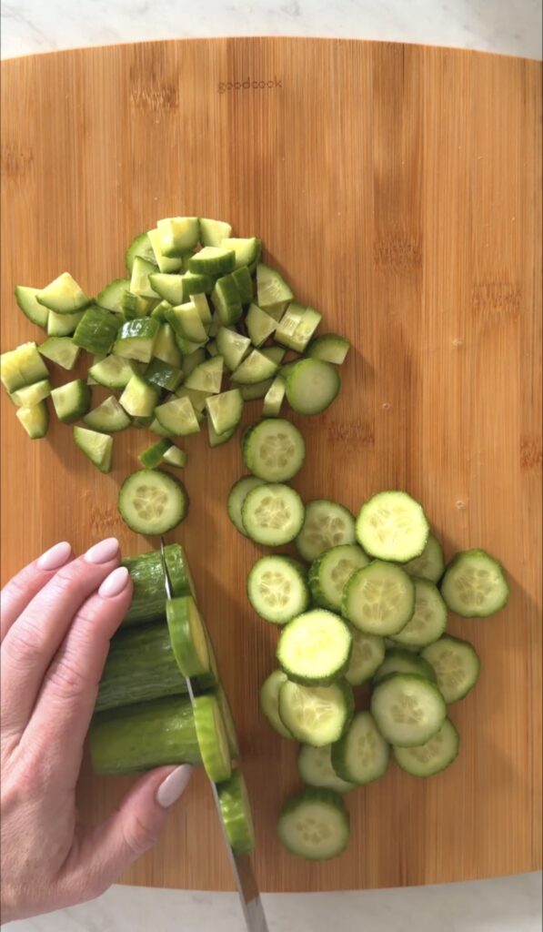 action shot slicing cucumber on a wooden cutting board
