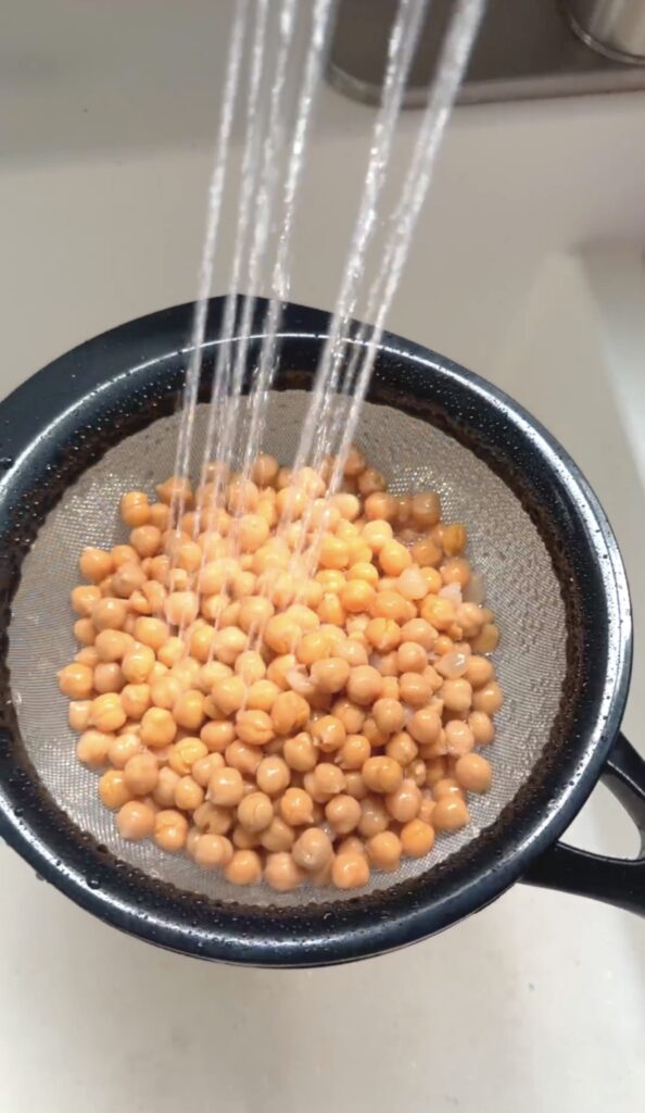 rinsing the chickpeas with water in a fine mesh colander.