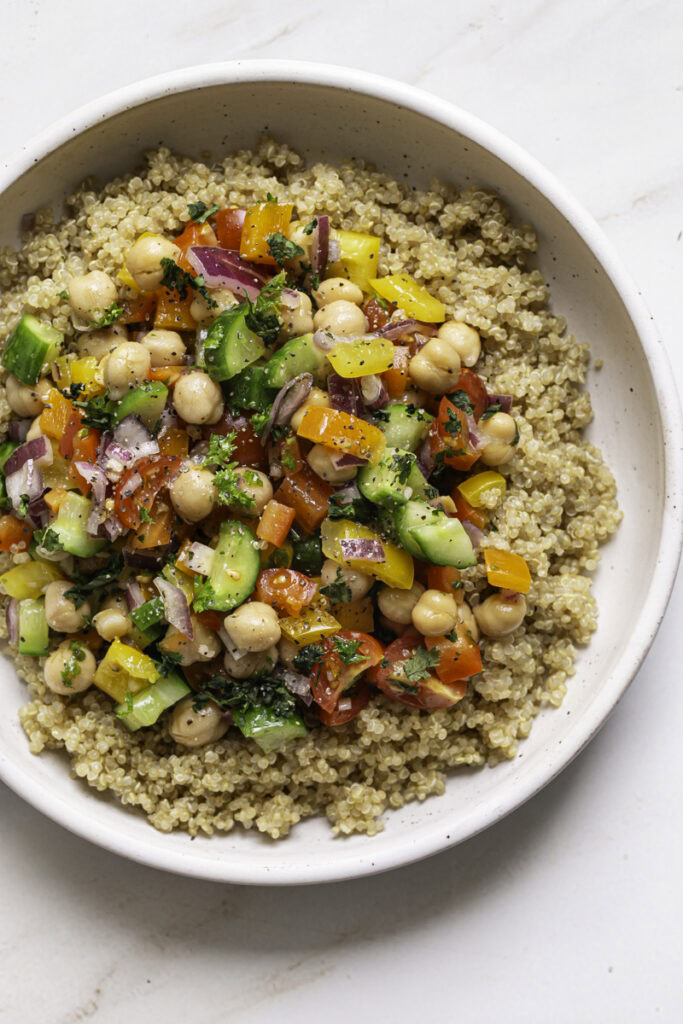 chickpea salad served over a bowl of quinoa.
