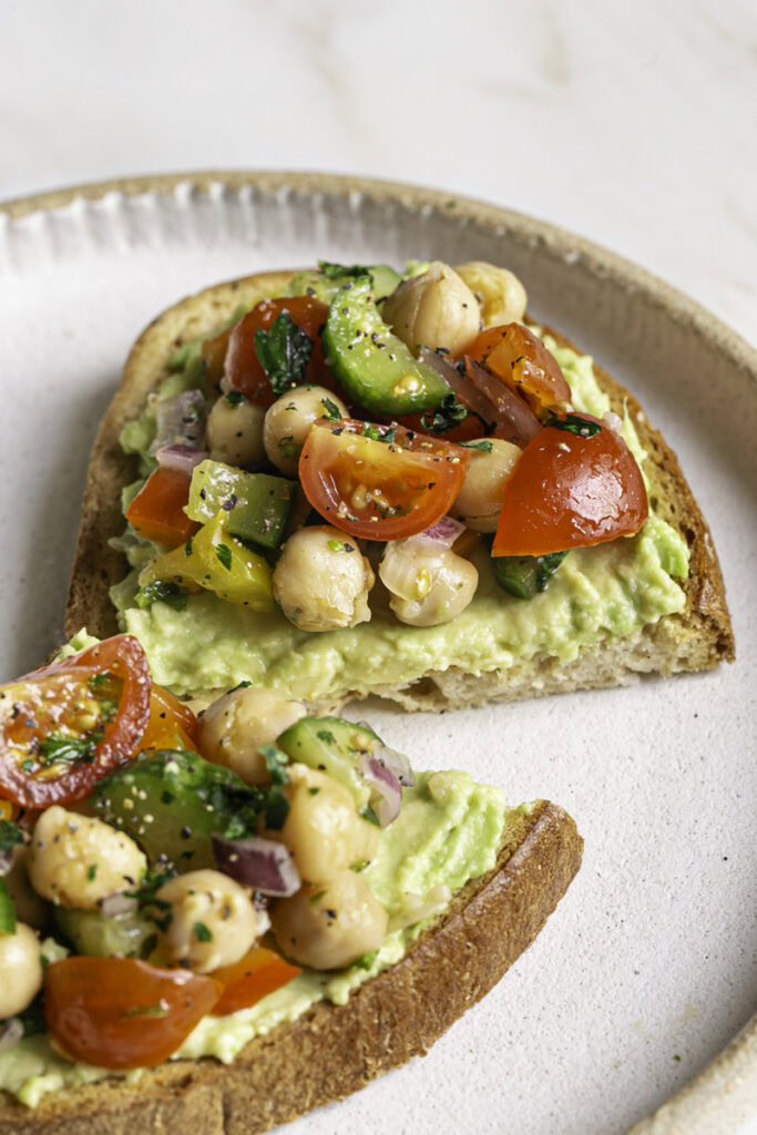 close up of chickpea salad served on top of avocado toast.