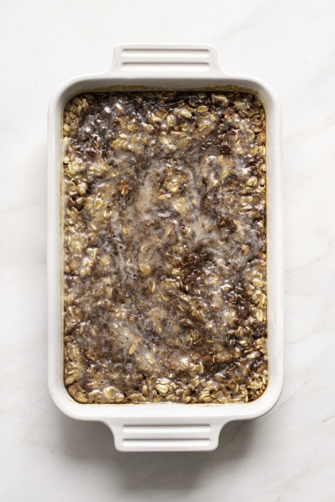 Unsliced, frosted cinnamon roll baked oatmeal.