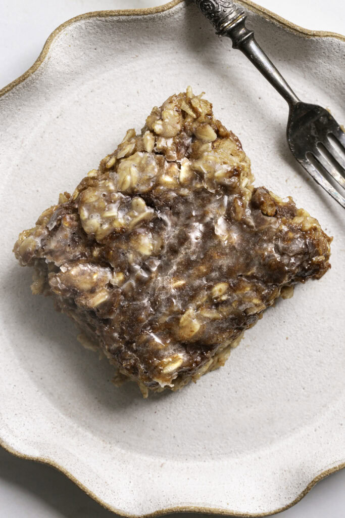 a slice of cinnamon roll baked oatmeal on a plate with a fork.