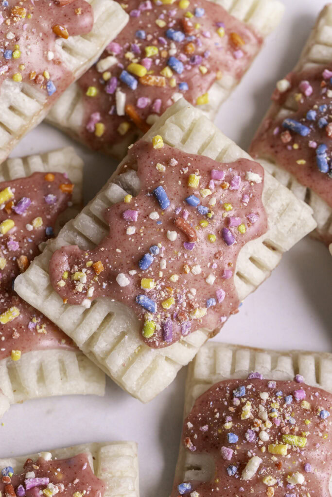 close up of mini strawberry chia pop tarts piled on top of one another.