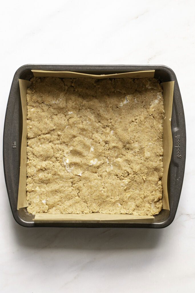 cinnamon cookie dough pressed into the baking pan ready to be baked.