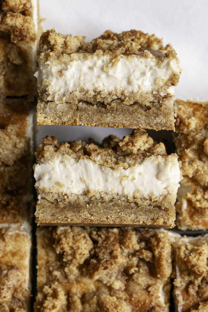 Cinnamon Cookie Cheesecake Crumb Bars sliced, 2 of the slices on their sides so you can see the cheesecake filling.