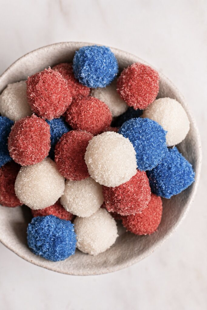 overhead shot of Sour Red White Blue Frozen Grapes piled in a bowl.