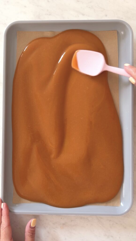 spreading the nectarine puree with a spatula on a parchment-lined baking sheet.