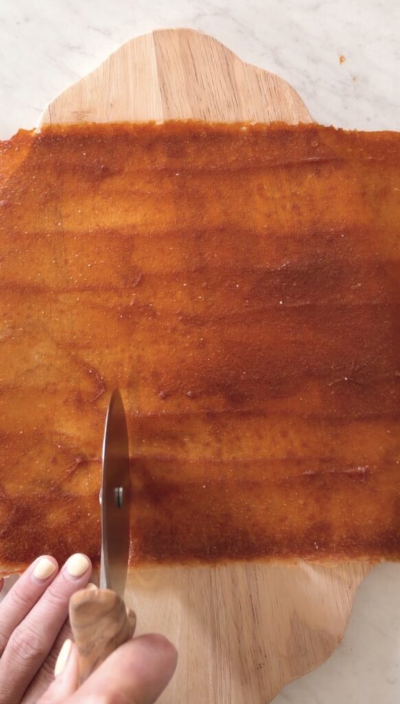 slicing the fruit leather with a pizza cutter.