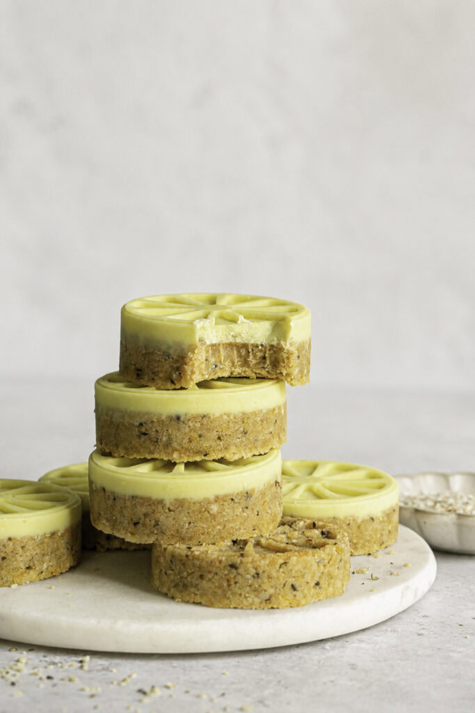 Lemon White Chocolate Hemp Quinoa Cookies stacked on top of one another, the top one with a bite taken out of it.