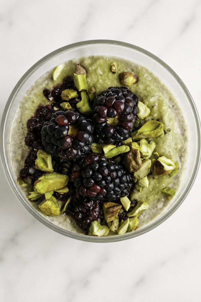 overhead shot of blackberry pistachio overnight oats with fresh blackberries on top.