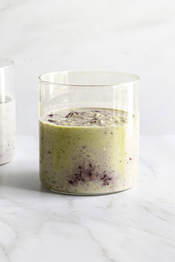 the rest of the overnight oats added to the jar with the pistachio cream and blackberry compote.