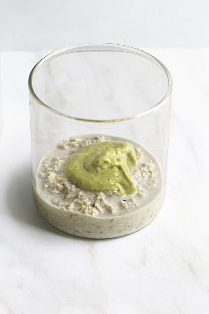 a dollop of pistachio cream on top of the overnight oats in a jar.