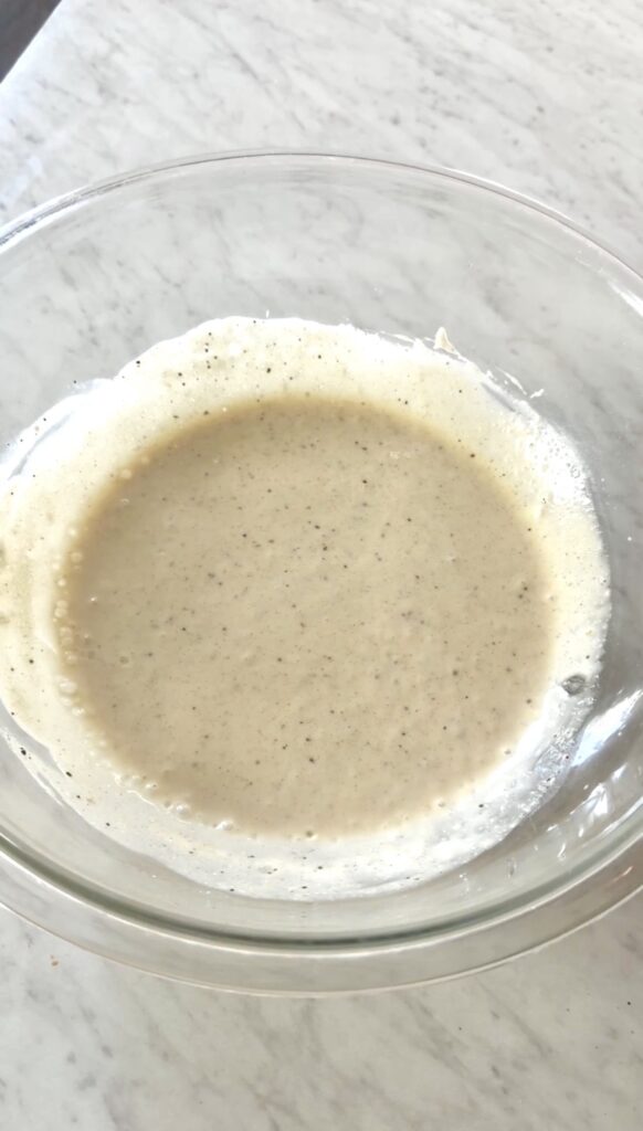 pasta salad dressing mixed in a large glass bowl.