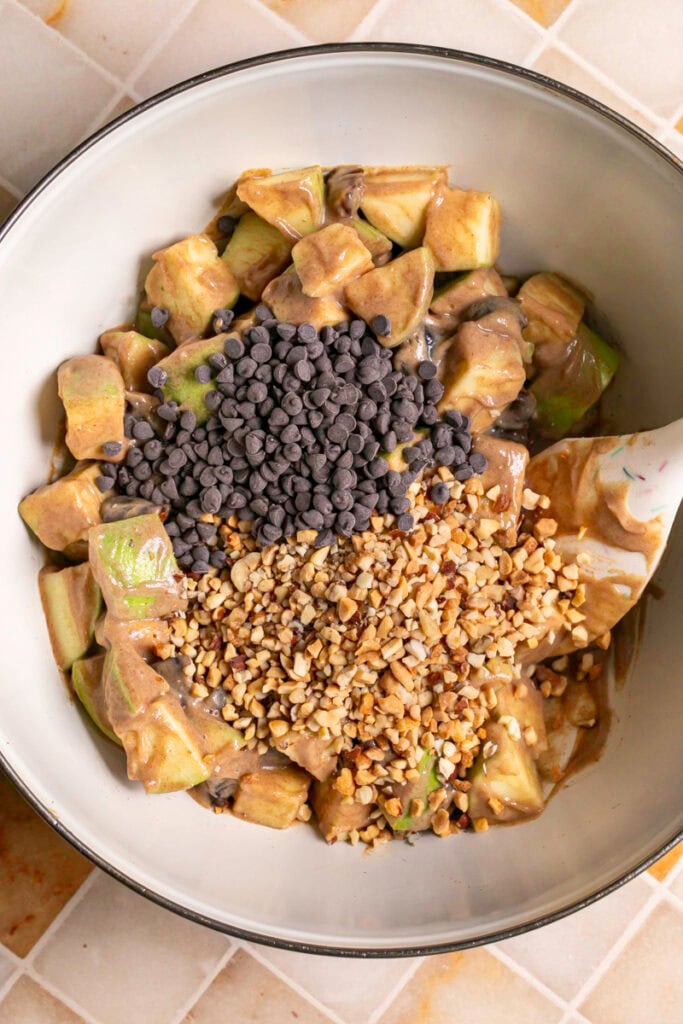 chocolate chips and chopped nuts added to the mixing bowl with the apples, dates and dressing.