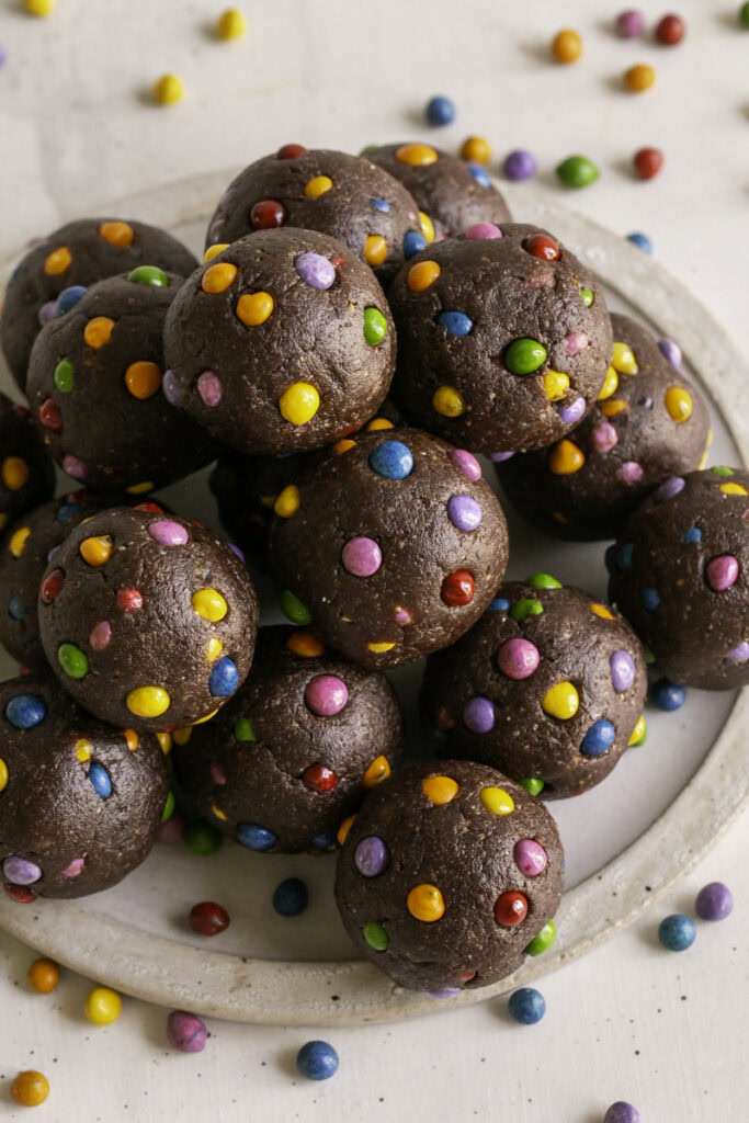 no-bake cosmic brownie cookie dough dates bites stacked on top of one another.